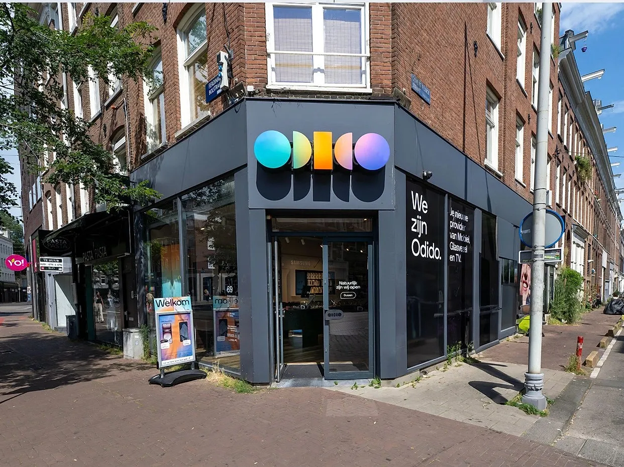 Strak telecomwinkelinterieur met lichte houten wanden bij daglicht